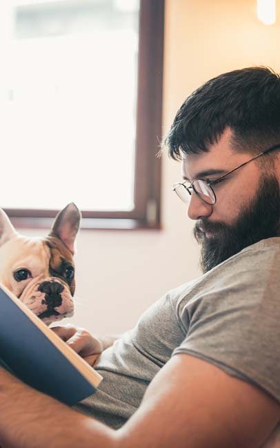Man enjoying a book with his Frenchie
